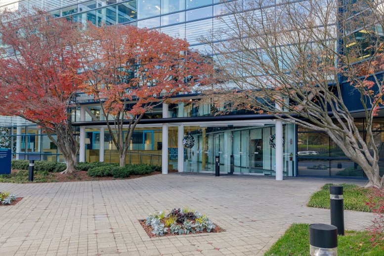 Exterior entrance of 1 Concourse Parkway NE with glass facade and colorful autumn trees.