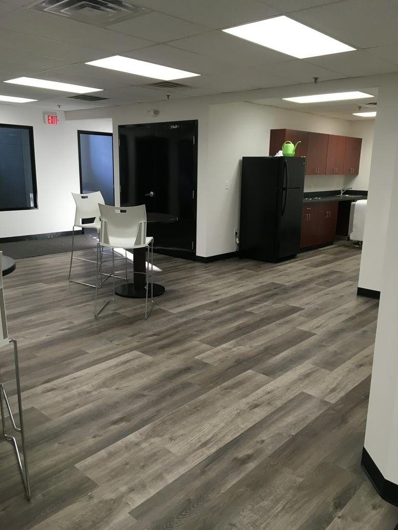 Spacious breakroom at 100 Cummings Center, Suite 109D with wood-style flooring and a kitchen area.