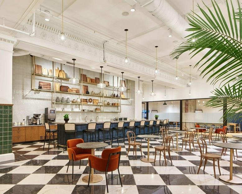 Spacious cafe and lounge at 100 East Penn Square with checkered floors and a large indoor palm tree.