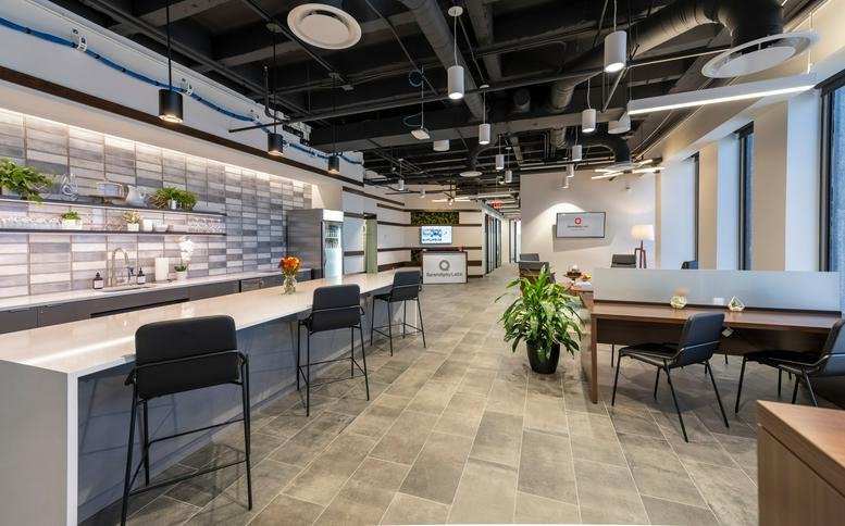 Spacious communal area with a kitchenette and bar seating.