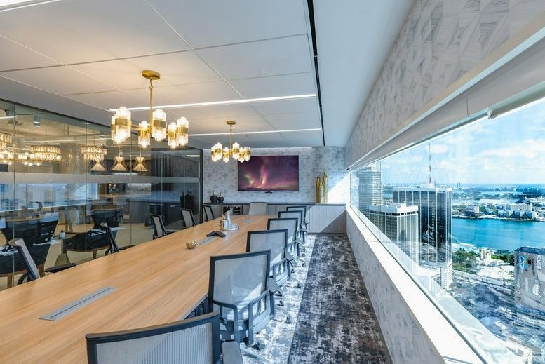 Spacious boardroom with a long wooden table and panoramic water views at Miami Tower.