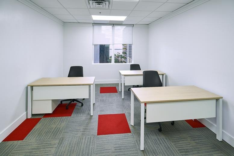 Spacious three-person office suite at 1000 Brickell Avenue, Suite 1100 with red carpet accents.