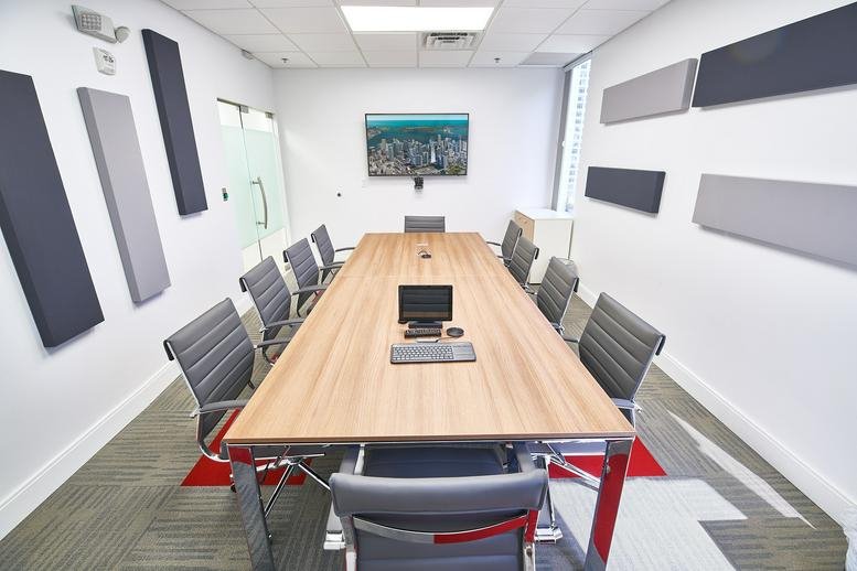 Large boardroom at 1000 Brickell Avenue, Suite 1100 with a long wooden table and sound-dampening wall panels.