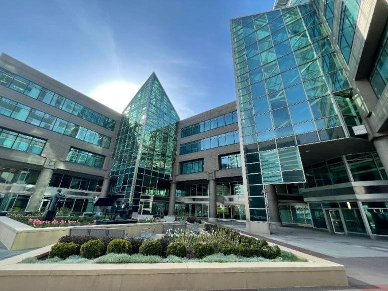 Modern glass exterior of 1001 East Lakeside Avenue with a geometric atrium and landscaped courtyard.