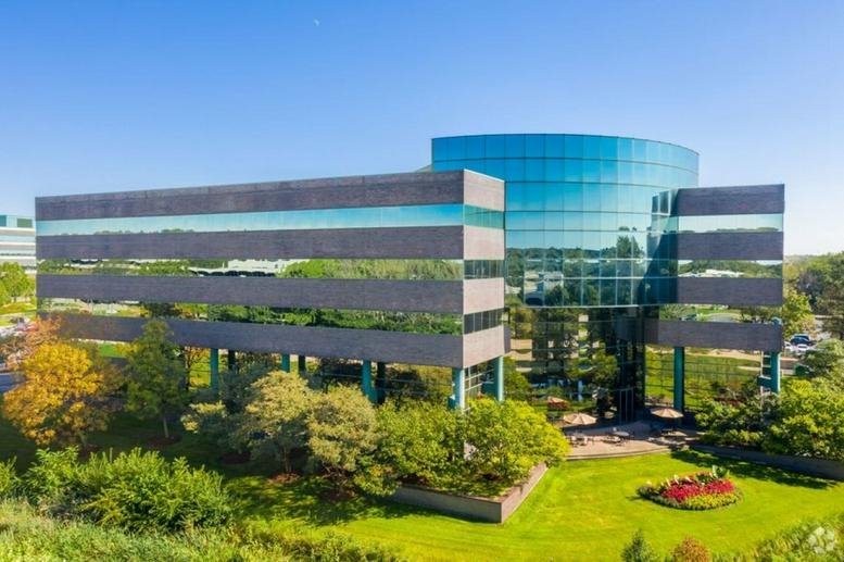 Exterior view of the multi-story glass and stone building at 1001 Warrenville Road, Suite 150.