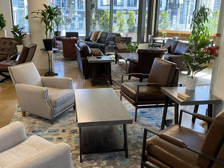 Spacious communal lounge at 1001 Wilshire Boulevard, First Floor featuring leather armchairs and natural light.