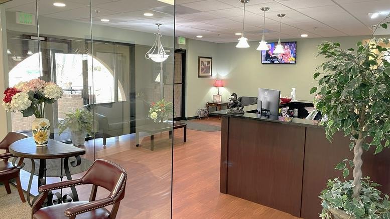 Reception area for 10015 Old Columbia Rd, Suite B215 with dark wood desk and glass partitions.