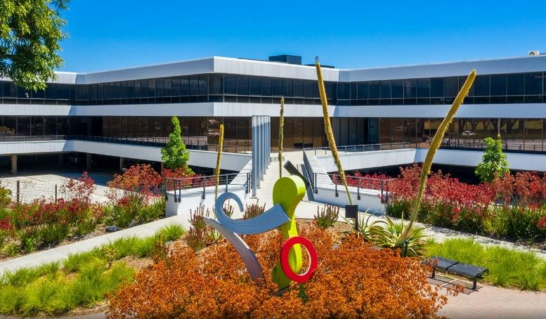 Exterior view of the modern office building at 10080 North Wolfe Road with vibrant landscaping.