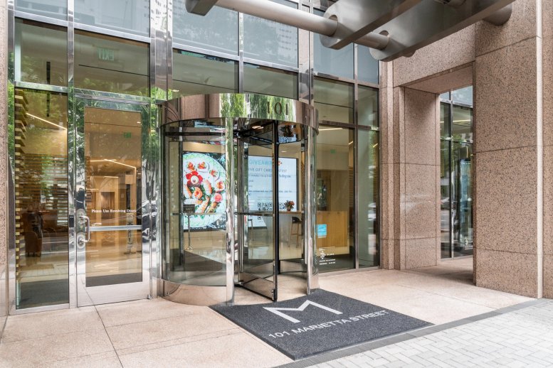 Entrance to 101 Marietta Street featuring glass revolving doors and a branded mat.