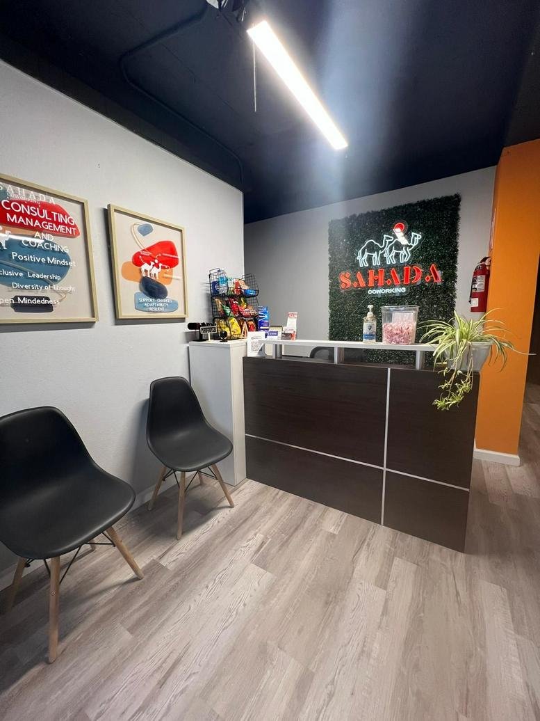 Reception area at 102 Calle Vives, Ponce, Puerto Rico with a wood-front desk and branded greenery wall.