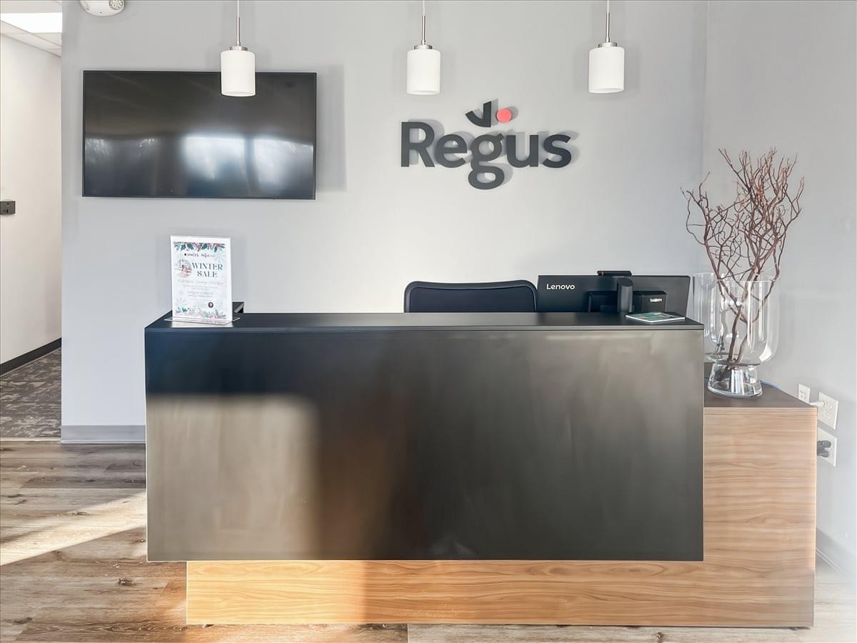Reception area at 1053 Farmington Avenue, 1st and 2nd Floor, featuring a dark wood desk and branded wall signage.