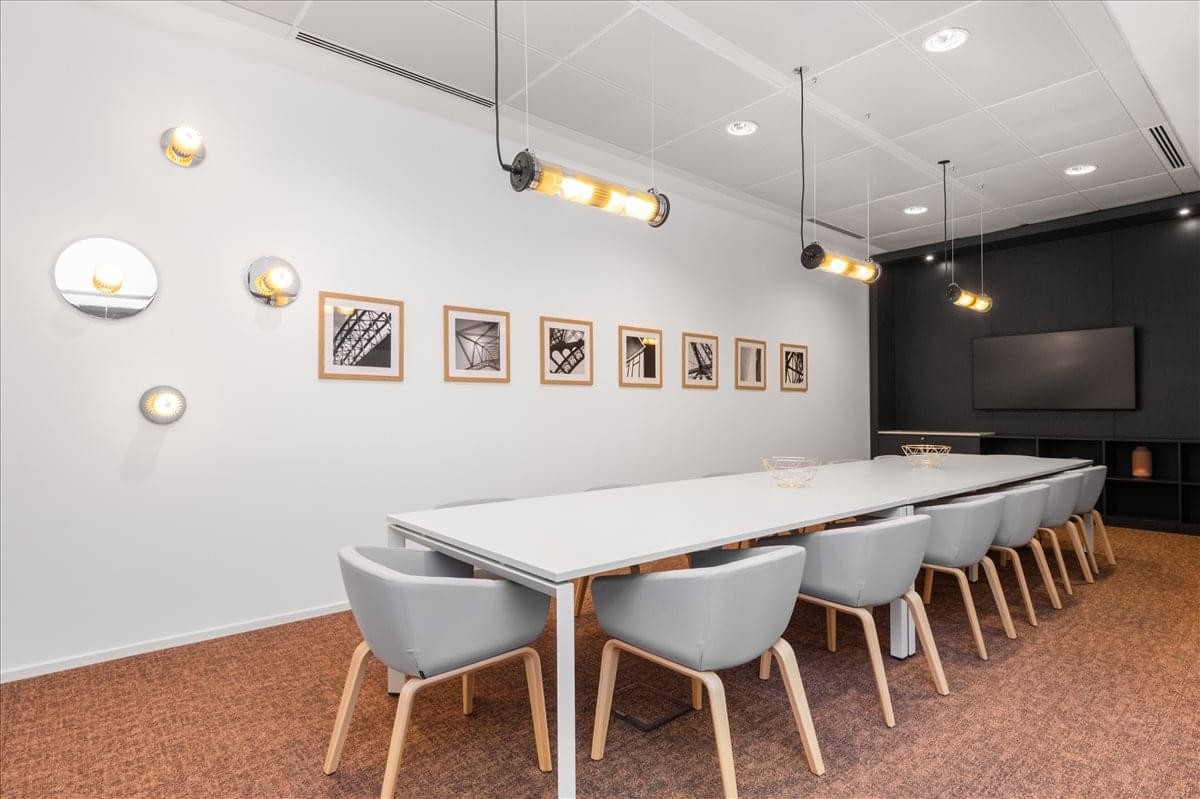 Spacious boardroom at Star Metals Office with long white table and modern light blue chairs.