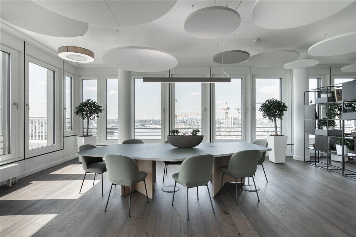 Modern communal area at Star Metals Office featuring organic-shaped tables and large windows.