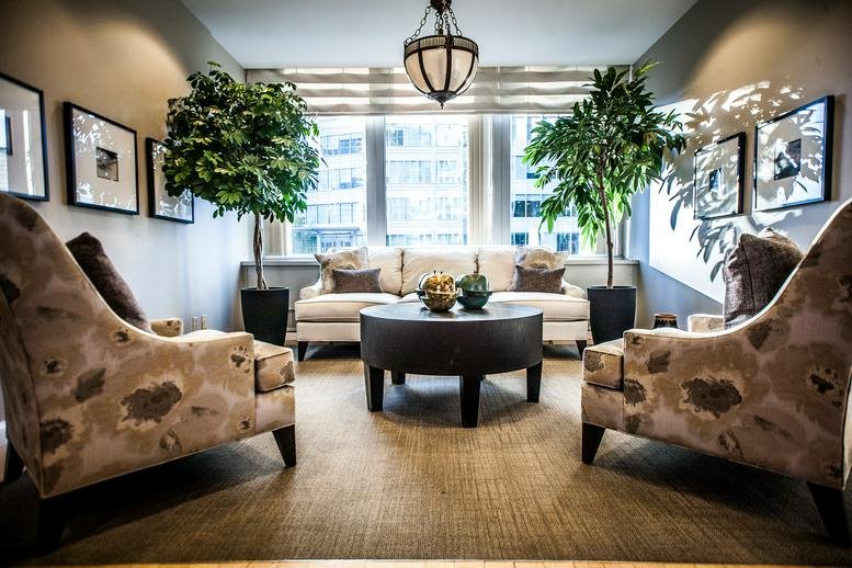 Brightly lit lounge area at 1055, West Hastings Street, Suite No. 300 with plush armchairs and large windows.