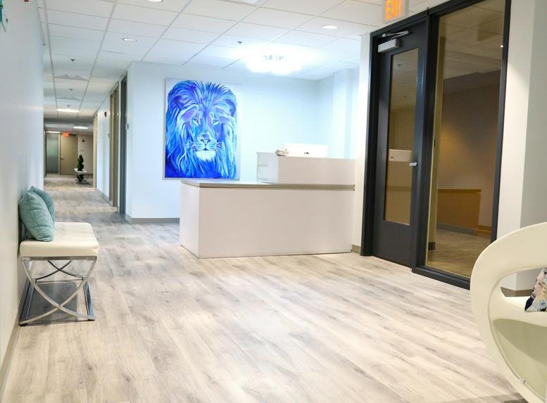 Reception area at 10770 Columbia Pike, Suite 300, with a white desk and a blue lion mural.