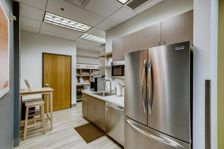 Spacious communal kitchen at 1079 S. Hover Street, Suite 200, with stainless steel appliances and wood cabinetry.