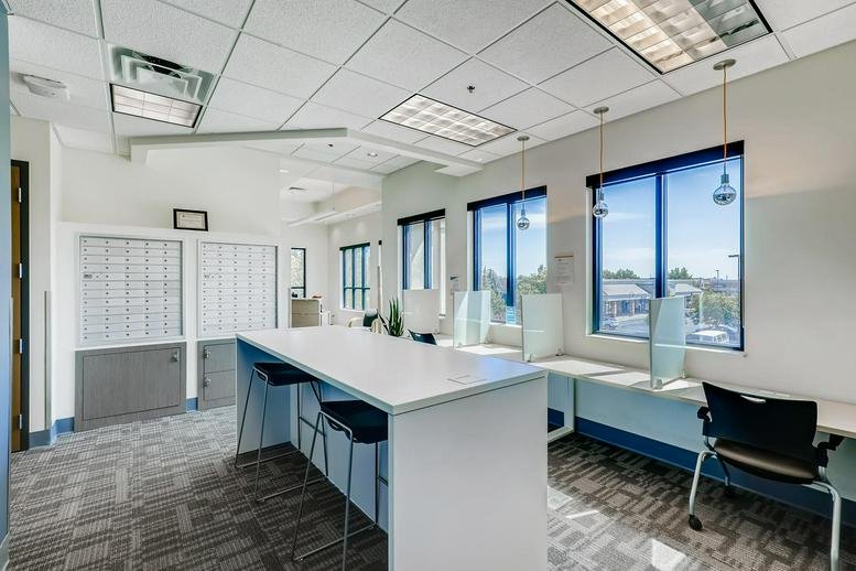 Spacious coworking area at 1079 S. Hover Street, Suite 200, Longmont, Colorado with large windows and high-top tables.