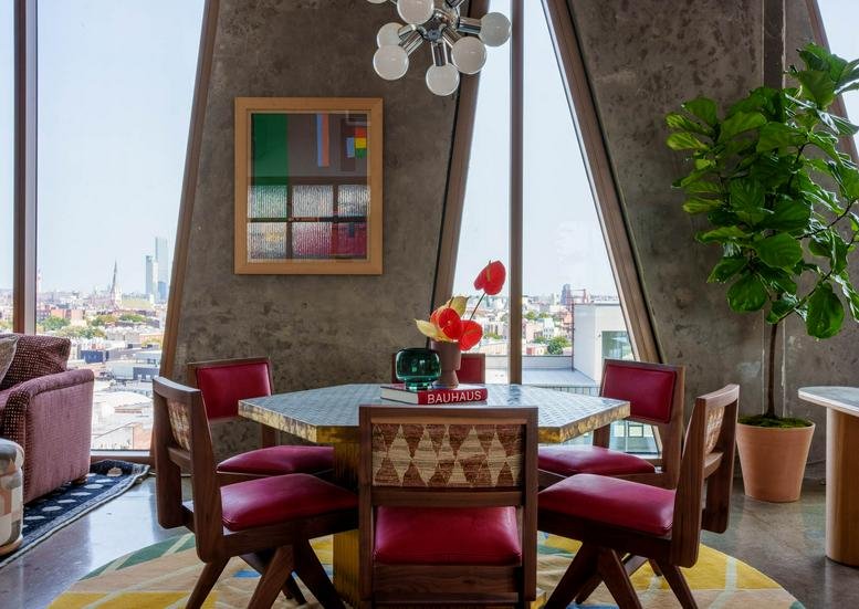 Colorful dining area with a round table and red chairs at 109 North 12th Street, The William Vale.