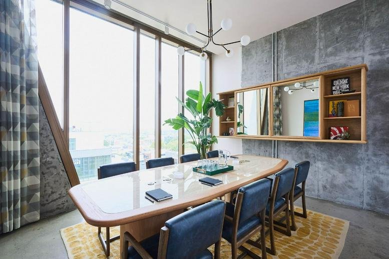 Conference room at 109 North 12th Street featuring a marble table, blue chairs, and concrete accent walls.