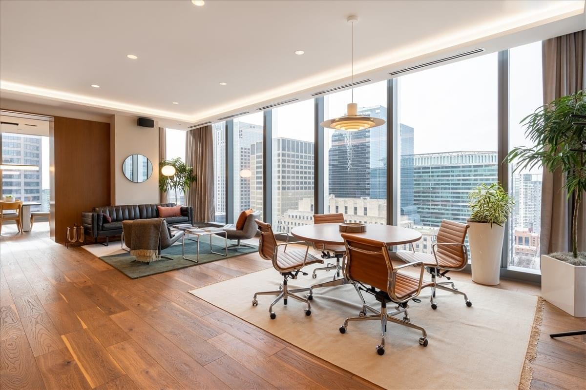 Upscale lounge at 110 North Wacker Drive featuring leather chairs and expansive city skyline views.