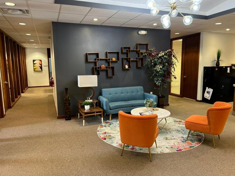 Spacious reception lounge at 115 South Court Street, Suite E, with colorful mid-century modern furniture.