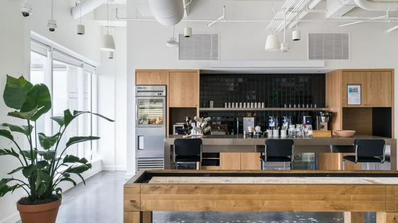 Spacious office breakroom at 1155 Perimeter Center West featuring a wooden shuffleboard table and kitchen area.