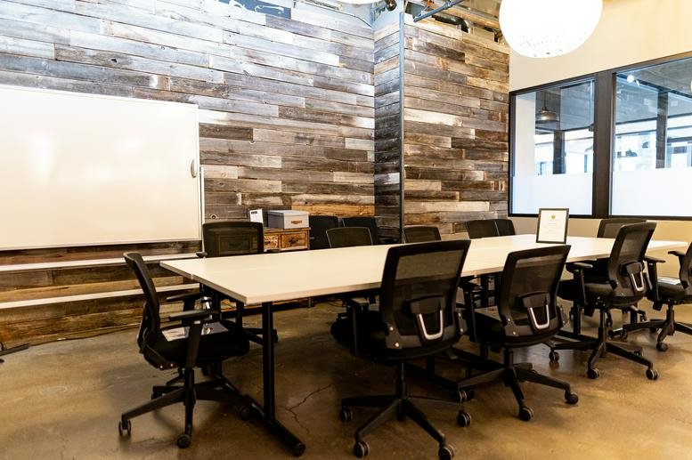 Meeting room at 1165 North Clark Street, Gold Coast, Suite 700 with a reclaimed wood feature wall and white table.