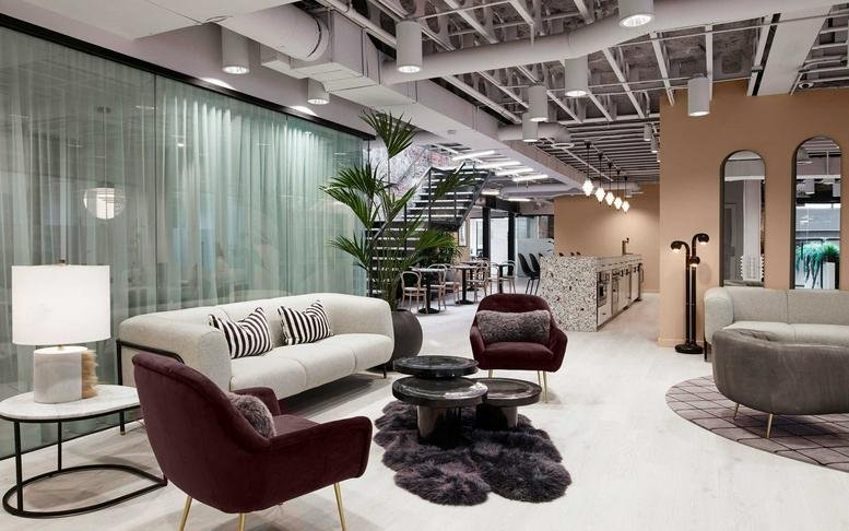 Spacious lounge at Bond Bushwick Center, 12 Park Street, featuring velvet armchairs and a modern white sofa.