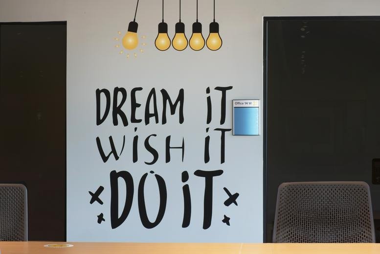 Feature wall with motivational quote and light bulb graphics.