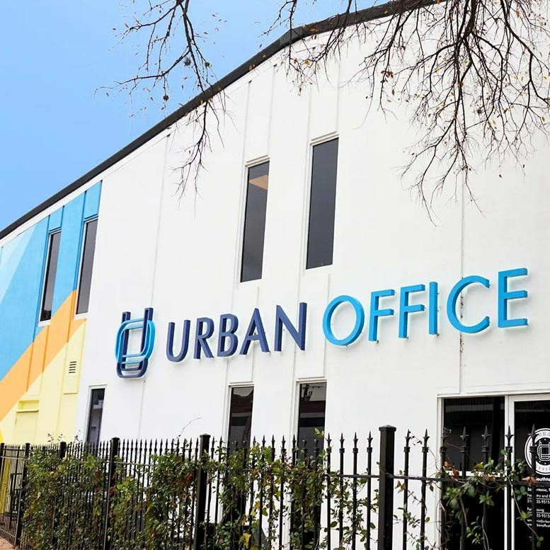 Exterior view of the white facade and entrance of Urban Office at 1209 South Saint Mary’s Street.