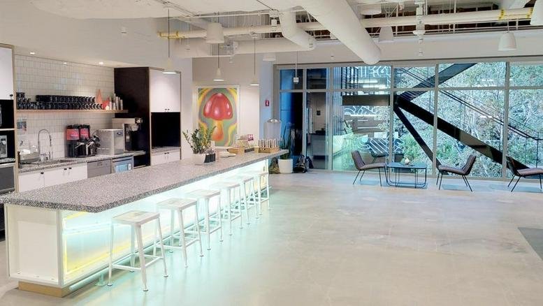 Spacious communal kitchen and cafe area at 12130 Millennium Drive with a long illuminated breakfast bar.