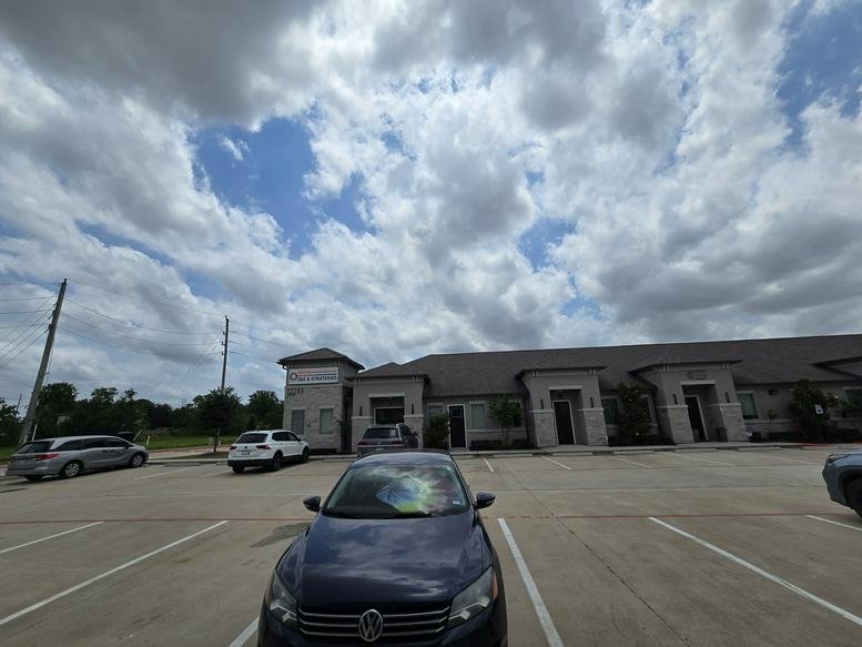 Wide view of the parking area in front of the single-story office building.