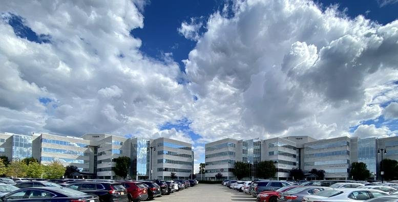 Exterior view of the multi-building office complex at 1225 Franklin Avenue under a bright cloudy sky.