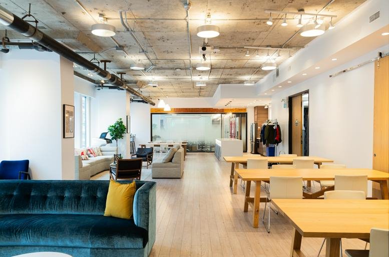 Spacious open-concept lounge at 123 Edward Street with velvet sofas and wooden dining tables.