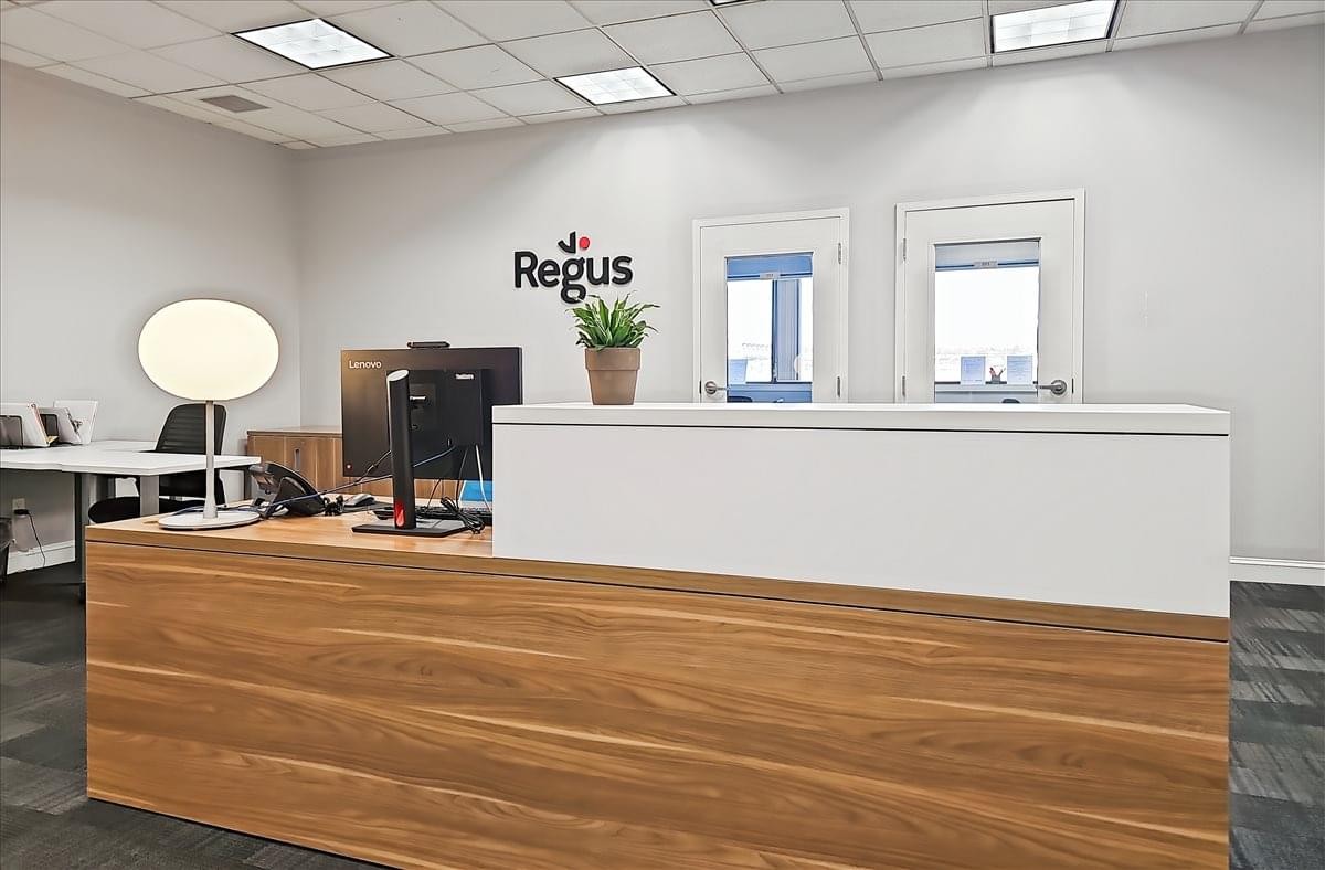 Reception area at 125 Eugene O’Neill Drive featuring a wood-fronted desk and branded wall signage.