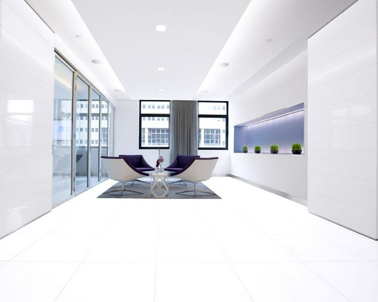 Sleek modern reception area with white floors and purple chairs at 125 Park Avenue, 25th Floor.