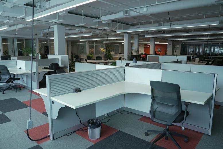 Spacious open-plan workspace at 1295 North Service Road with ergonomic chairs and modular desks.