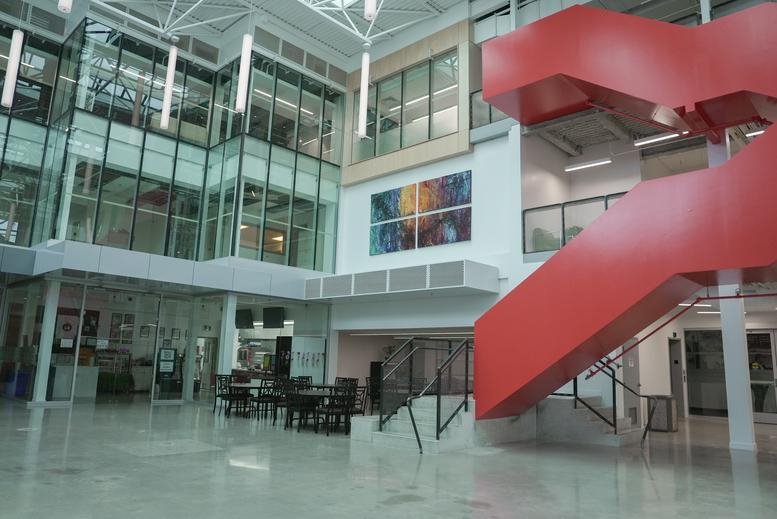 Bright multi-level atrium at 1295 North Service Road with a feature red staircase and glass walls.