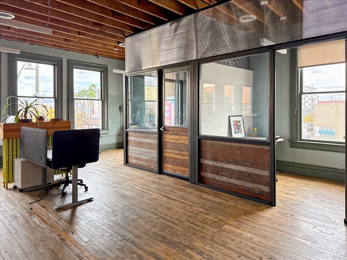 Spacious office interior at 130 East Congress Street with exposed wood ceilings and glass partition walls.
