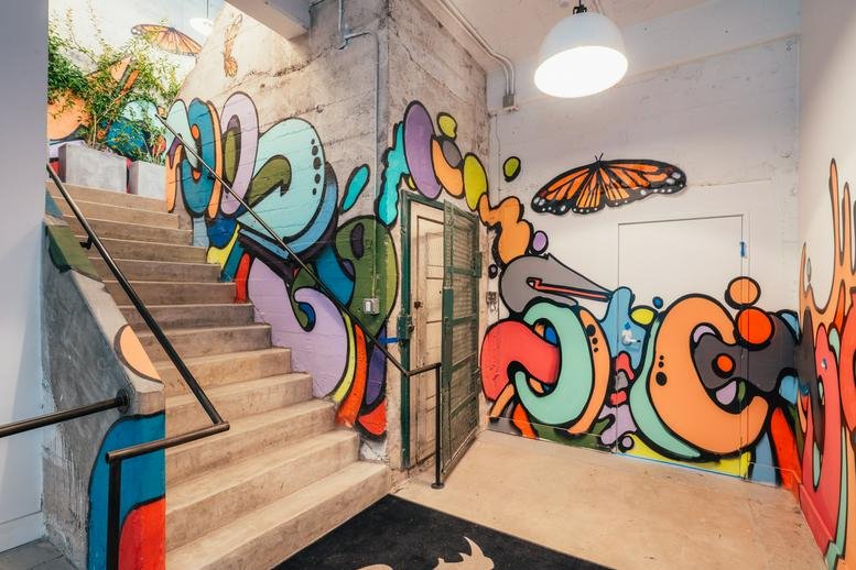 Colorful graffiti mural and butterfly art in the stairwell entrance at 1325 Palmetto Street.