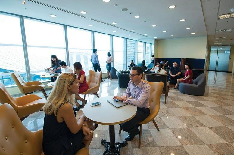 Spacious coworking area with comfortable armchairs and floor-to-ceiling windows.