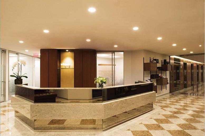 Elegant stone reception desk in a well-lit lobby with wooden wall accents.