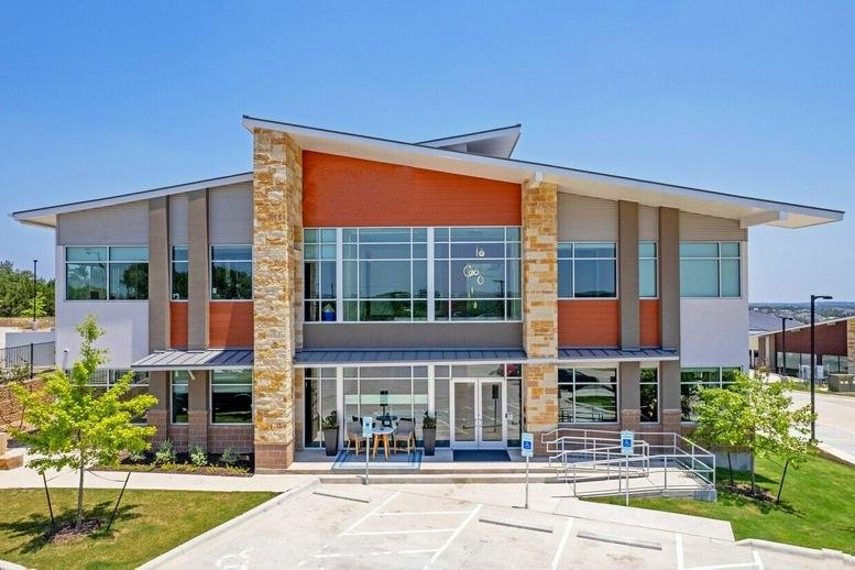 Exterior view of 13341 West United States Highway 290, Building 2 with stone pillars and large windows.