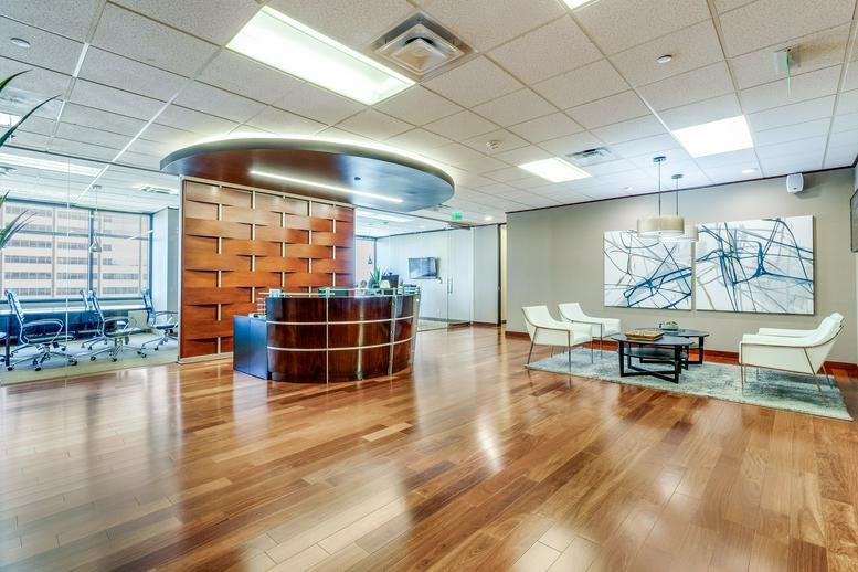 Modern reception lobby with a curved wood desk and a large abstract painting.