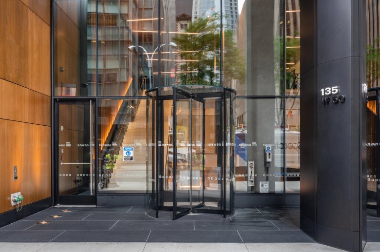 Street-level entrance of the 135 W 50th Street building with a glass revolving door.