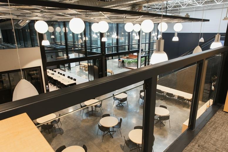 Spacious communal dining area at 137 Glasgow St, Suite 210, Kitchener with round tables and modern lighting.