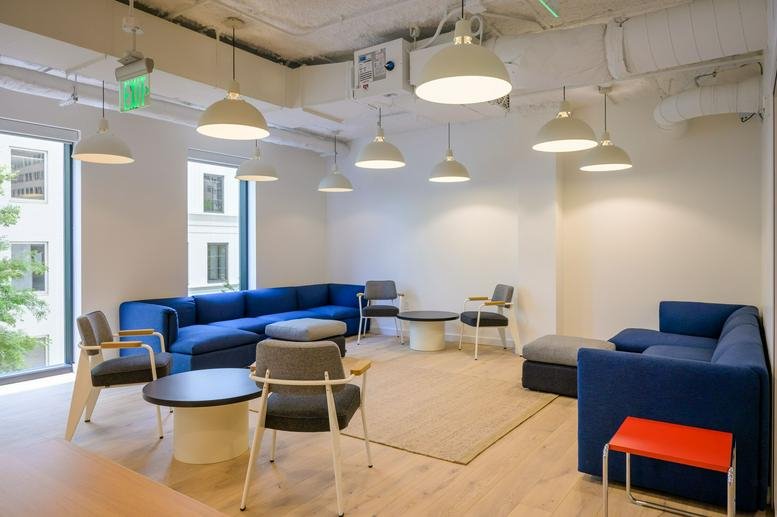 Spacious communal lounge at 1389 Peachtree Street with blue sofas and industrial-style pendant lighting.