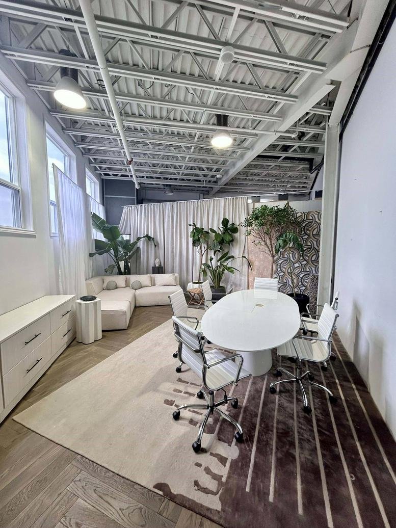 Spacious meeting area with a white oval table and industrial ceiling at 14 Leswyn Road, Toronto, Ontario.