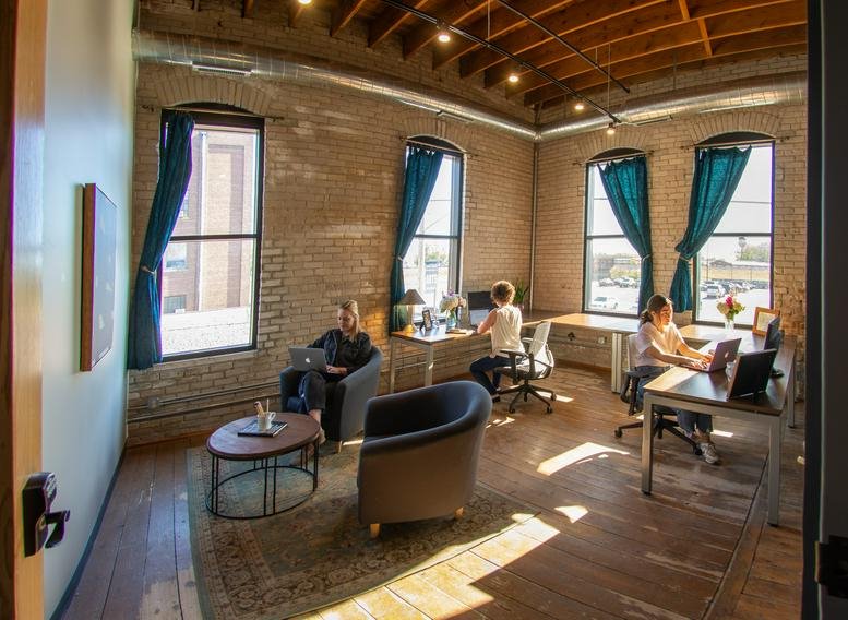 Spacious communal lounge in the Van Buren Building with brick walls and large windows.