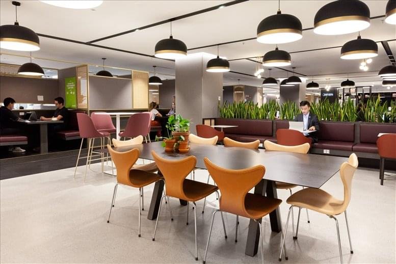 Communal area with large wooden table and modern chairs.